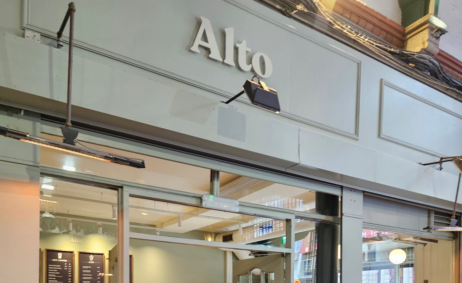 The sage-green Alto sign above the shopfront, under George's Street Arcade's dark ironwork.