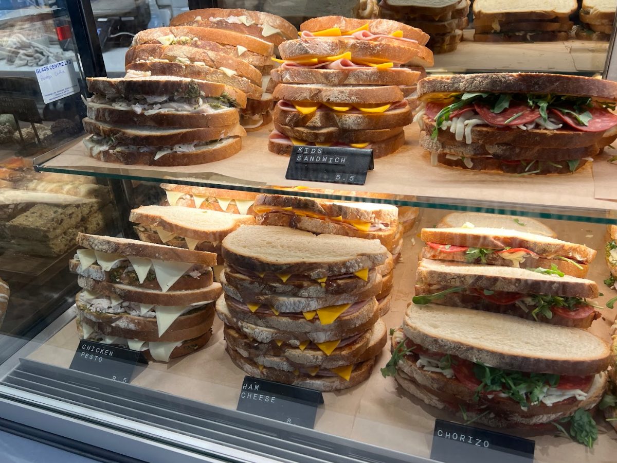 Sandwiches labelled chicken pesto, ham and cheese and chorizo in Alto's glass display case.